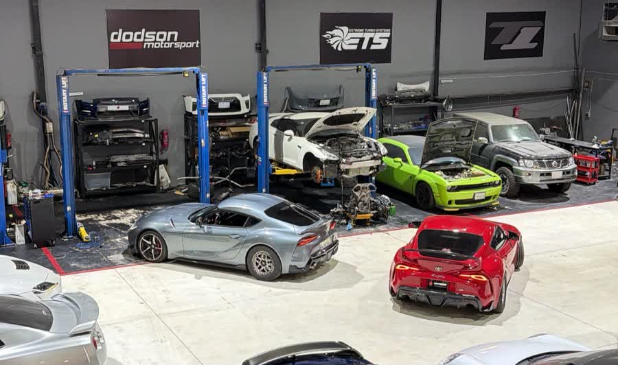 Overview of the workshop with cars on lifts and partner brand banners