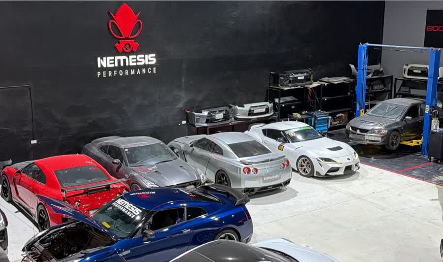Wide view of GT-Rs, a Supra and an Evo inside the Nemesis Performance workshop