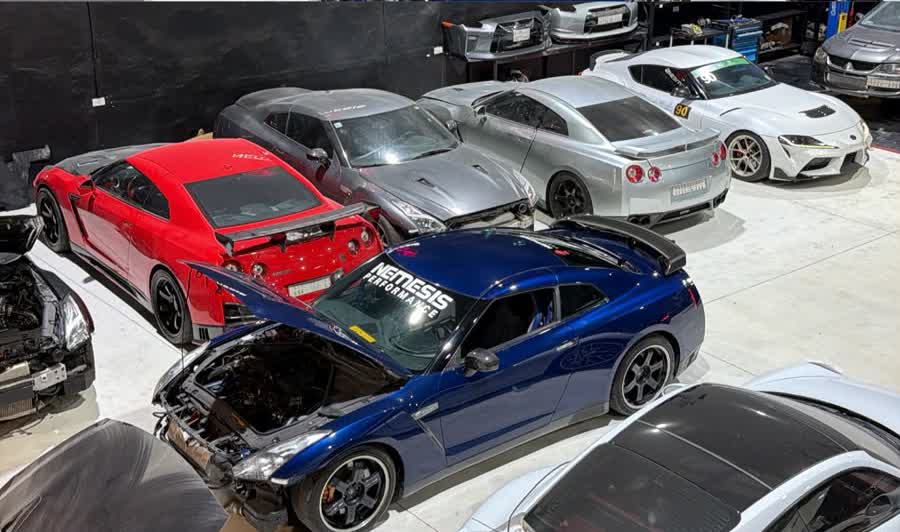 Line-up of Nissan GT-Rs and a Supra inside the workshop