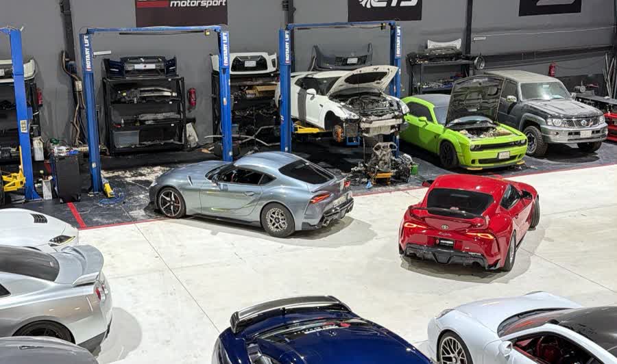 Workshop lifts with stripped cars and an engine out on the floor