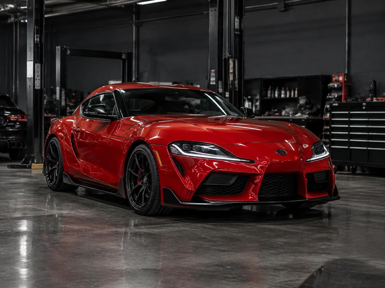 Red 2023 Toyota Supra inside the Nemesis Performance workshop